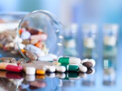 Colorful tablets with capsules and pills on blue background