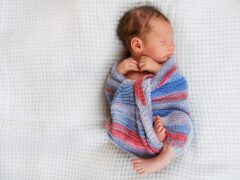 newborn baby wrapped up in a blanket sleeping