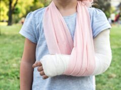 Child with broken arm and cast in sling