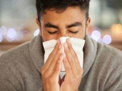 What am I going to do about this flu. Shot of a young man blowing his nose.