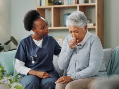 Home, nurse and senior woman with cough or healthcare consultation, support or help. Sick, patient or elderly caregiver nursing person in hospice with lung cancer, tuberculosis or breathing with asma