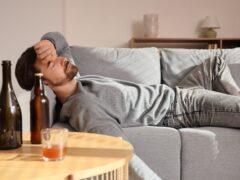 Drunk man lying on sofa. Alcoholism concept