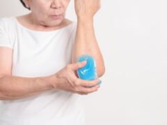 Elderly Woman having elbow ache and Edema with Cold Gel pack for concepts of Tennis Elbow, muscle pain and Sprain, lateral epicondylitis, Bursitis, injury, Senior Health care and medical
