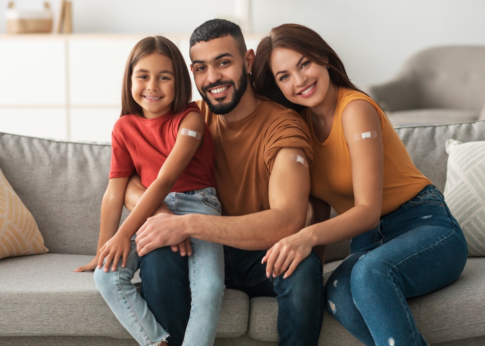 A family with bandages over their recent vaccines.